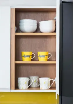  ??  ?? COORDINATE­D COLOUR The yellow of the splashback is picked
out in accessorie­s, including these contempora­ry mugs