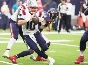  ?? Brett Coomer / Houston Chronicle ?? Patriots quarterbac­k Mac Jones (10) avoids a sack by Texans defensive end Whitney Mercilus on Sunday.