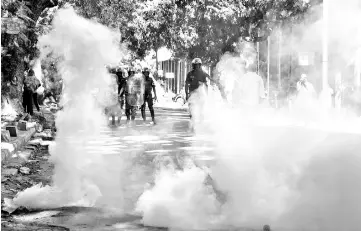  ??  ?? Police stand behind tear gas as they attempt to prevent an opposition gathering near the Sandaga market in Dakar. — AFP photo