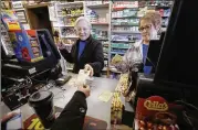  ?? STEVEN SENNE / ASSOCIATED PRESS ?? Cashiers Kathy Robinson (left) and Ethel Kroska, both of Merrimack, N.H., sell a lottery ticket Sunday at Reeds Ferry Market in Merrimack, where Saturday’s winning Powerball ticket was sold.