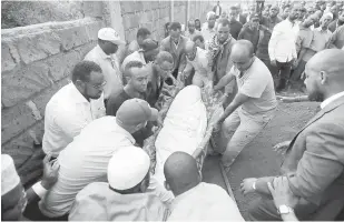  ?? — Gambar Reuters ?? SELAMAT DIKEBUMI: Orang ramai mengangkat jenazah Feisal Ahmed Rashid yang maut dalam serangan ke atas sebuah pekarangan hotel mewah, di tanah perkuburan Islam Langata, di Nairobi, Kenya pada Rabu.