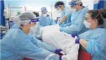  ??  ?? Critical care staff move a Covid-19 patient at King’s College Hospital in London. Photo / AP