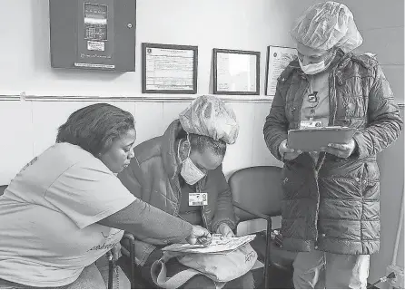  ?? ALYSSA STONE/ USA TODAY NETWORK ?? Malika Jamal helps Good Samaritan Hospital staff members Cleusa Cordozo and Fernanda Ortiz fill out paperwork for child care at Agape Child Care and Family Life Center in Brockton, Mass., in March.