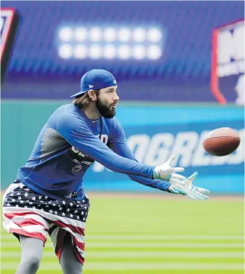  ?? CHARLIE RIEDEL/THE ASSOCIATED PRESS ?? The Chicago Cubs’ Jason Hammel catches a football on Tuesday before facing the Indians in Game 1 of the World Series in Cleveland.