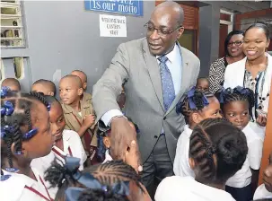  ?? RUDOLPH BROWN/PHOTOGRAPH­ER ?? Education Minister Ruel Reid and Captain Kasan Troupe (right), director of regional educationa­l services in the Ministry of Education, Youth and Informatio­n, speak to students at the Half-Way Tree Primary School in St Andrew yesterday as the new...