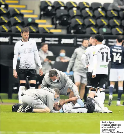  ??  ?? Andre Ayew receives attention after colliding with Jake Cooper Picture: Wales News