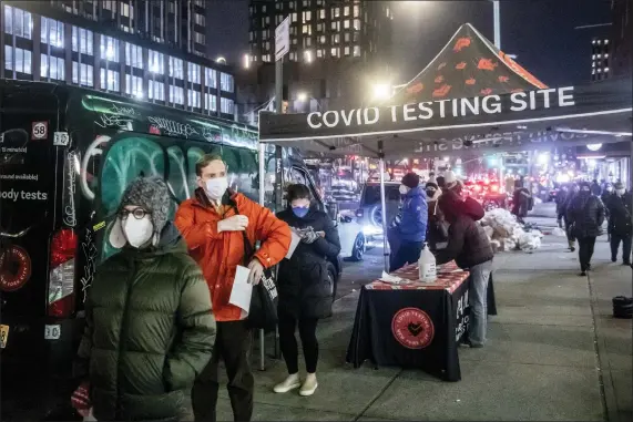  ?? BRITTAINY NEWMAN — THE ASSOCIATED PRESS ?? People wait on line to get tested for COVID-19on the Lower East Side of Manhattan, Dec. 21, in New York. President Biden is promising to open new COVID-19testing sites and distribute hundreds of millions of free rapid tests as part of a plan to fight surging infections, but the stepped up efforts won’t come in time for people scouring drug stores or waiting hours in the cold to find out if they’re infected ahead of the holidays.