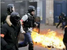  ?? KAMIL ZIHNIOGLU - THE ASSOCIATED PRESS ?? Riot police run past burning dustbins set on fire by yellow vest protesters as they keep pressure on French President Emmanuel Macron’s government, for the 13th straight weekend of demonstrat­ions, in Paris, France, Saturday, Feb. 9.