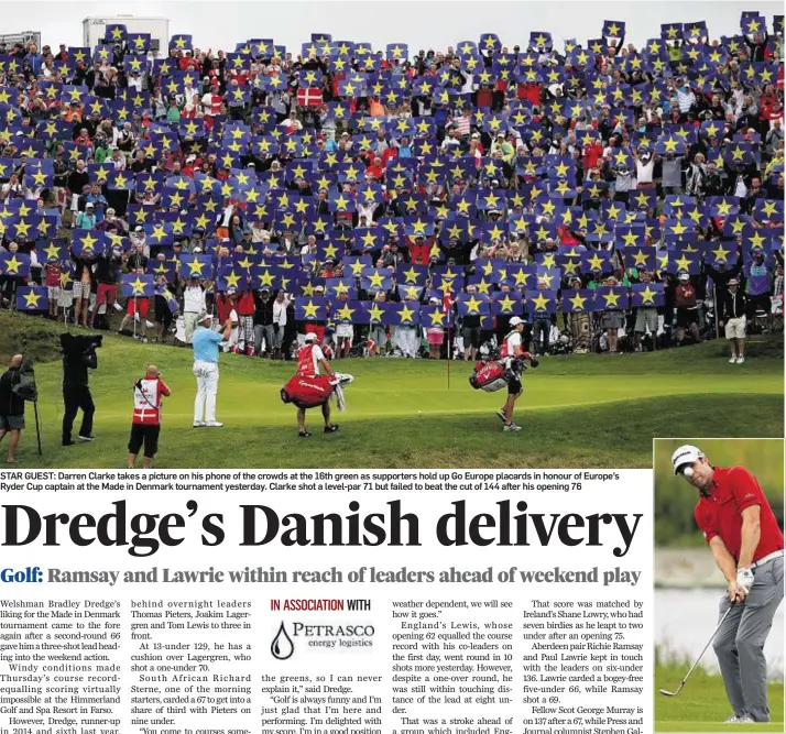  ??  ?? STAR GUEST: Darren Clarke takes a picture on his phone of the crowds at the 16th green as supporters hold up Go Europe placards in honour of Europe’s Ryder Cup captain at the Made in Denmark tournament yesterday. Clarke shot a level-par 71 but failed...