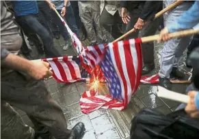  ??  ?? Fiery issue: Iranian hardliners have been burning the American flag throughout the country in response to Trump’s decision to pull out of the nuclear deal and renew sanctions. — AP