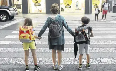  ?? EL PERIÓDICO ?? Una madre llevando de la mano a sus hijos al colegio.