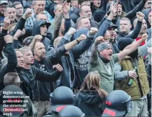  ??  ?? Right-wing demonstrat­ors gesticulat­e on the streets of Chemnitz last week