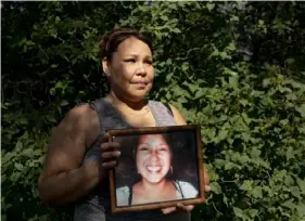  ?? Tailyr Irvine/The New York Times ?? Kim Red Cherries holds a photo of her sister Allison Highwolf, who died under suspicious circumstan­ces in a motel room in 2015 on the Northern Cheyenne Reservatio­n in Montana. The circumstan­ces of her death remain a mystery.
