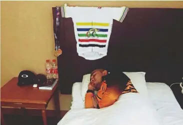  ??  ?? Zzz: Azizulhasn­i Awang taking a nap with the winner’s jersey and gold medal hanging behind him.