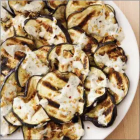  ??  ?? This undated photo provided by America’s Test Kitchen in July 2018 shows grilled eggplant with yogurt sauce in Brookline, Mass. This recipe appears in the cookbook “The Complete Mediterran­ean Cookbook.”