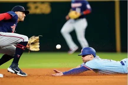  ?? AP Photo/Tony Gutierrez ?? Minnesota Twins shortstop Carlos Correa reaches out for the throw to the bag before tagging out Texas Rangers’ Brad Miller, who was trying to steal second, in the fourth inning Sunday in Arlington, Texas.