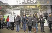  ?? JOSHUA LOTT/GETTY IMAGES ?? Demonstrat­ors block the entrance to a shop Friday along Chicago’s Magnificen­t Mile shopping district.