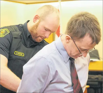  ?? FILE PHOTO ?? A sheriff’s officer puts handcuffs on Thomas James Keeping, 32, before escorting him back to the lockup at provincial court in St. John’s, during a break in his trial. Keeping was convicted Wednesday of stabbing a man last fall in St. John’s.