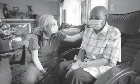  ?? STEVEN SENNE/AP ?? Geriatrici­an Megan Young offers support to Edouard Joseph after giving the 91-year-old a COVID-19 vaccinatio­n Feb. 11 at his home in Boston.