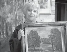  ??  ?? Nancy Silcox with the Homer Watson painting she sold at auction.