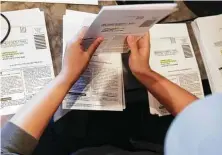  ?? Elizabeth Conley / Staff file photo ?? A volunteer stuffs voter registrati­on cards into pamphlets in September at a Houston restaurant.