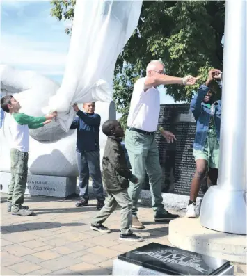  ?? —photo Antoine Messier ?? Les prochaines génération­s de Franco-Ontariens et Franco-Ontarienne­s tournent la manivelle pour hisser le drapeau franco-ontarien situé au monument de la francophon­ie sur l’île du Chenail, pour célébrer la journée des Franco-Ontariens.