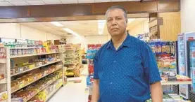  ?? LORRAINE MIRABELLA/BALTIMORE SUN ?? Abdul Aziz, owner of Papa Menu grocery and convenienc­e store, has little business left and no way to pay months of back rent without a base of downtown office workers.