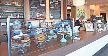  ?? ANGELA PETERSON, MILWAUKEE JOURNAL SENTINEL ?? A collection of cake stands holds shortbread and more as Kate Ryndell prepares a latte at Miss Molly's Cafe & Pastry Shop.