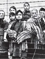  ??  ?? Children behind the wire fences of Auschwitz