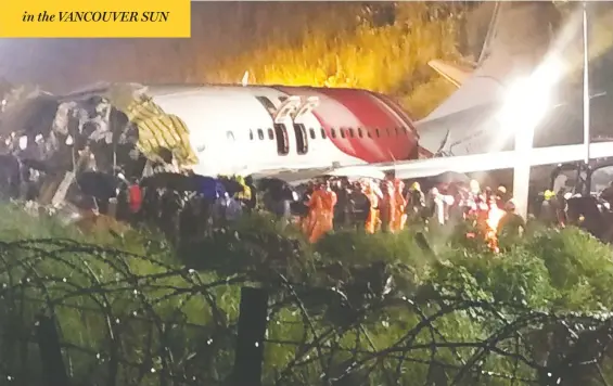  ?? AFP VIA GETTY IMAGES ?? First responders gather around the wreckage of an Air India Express jet, which was carrying 190 passengers and crew from Dubai, after it crashed in heavy rain by overshooti­ng the runway at Calicut Internatio­nal Airport in Kozhikode in the southern state of Kerala on Friday. Both pilots were among the dead.