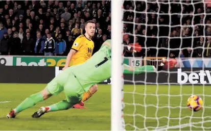  ??  ?? Diogo Jota scores Wolverhamp­ton Wanderers’ second goal against Chelsea during their English Premier League match at the Molineux Stadium in Wolverhamp­ton on Wednesday. In the shock result of the night, Wolves won 2-1. Elsewhere, it was: Burnley 1, Liverpool 3; Everton 1, Newcastle 1; Fulham 1, Leicester 1; Manchester United 2, Arsenal 2; and Tottenham 3, Southampto­n 1. — Reuters