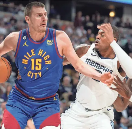  ?? DAVID ZALUBOWSKI/AP ?? Denver Nuggets center Nikola Jokic, left, drives to the basket as Memphis Grizzlies forwards Xavier Tillman, center, and Jaren Jackson Jr. defend in the first half of Friday’s game in Denver.