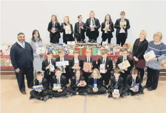  ??  ?? Hetton School staff Amran Suleman, Gloria Cairns, Megan Pigg and Louise Birtcham and pupils with items of food collected in aid of the foodbank.