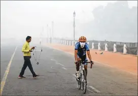  ?? MANISH SWARUP / ASSOCIATED PRESS ?? A cyclist pedals through the morning smog in New Delhi on Friday. Environmen­tal pollution — from filthy air to contaminat­ed water — is killing more people every year than all the war and violence in the world.