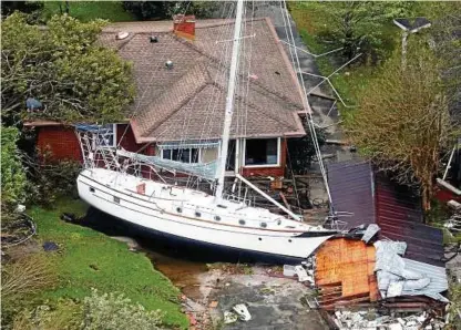  ??  ?? Auf seinem Weg ins Landesinne­re der USA brachte Wirbelstur­m „Florence“Verwüstung. In New Bern strandete ein Segelboot vor einem Haus. Foto: dpa