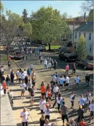  ?? RECORD FILE PHOTO ?? Walkers make their way down 114th Street in front of the Lansingbur­gh Boys & Girls Club to finish a 1-mile run that kicked off the first Joseph G. Manupella Memorial Run.