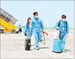  ?? VIETNAM NEWS AGENCY ?? Vietnamese citizens returning from the US leave the plane after landing at Van Don Internatio­nal Airport in Vietnam’s Quang Ninh province on Sunday.