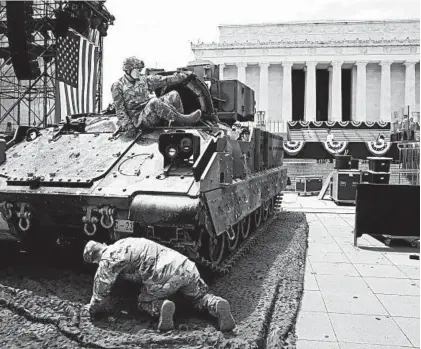  ?? MARK WILSON/GETTY ?? Soldiers prepare an M1 Abrams tank on Wednesday for display near the Lincoln Memorial.