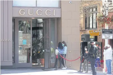  ?? IMAGES/AFP GETTY ?? People wait in line to enter a Gucci store in the Union Square shopping district in San Francisco, California on April 15.