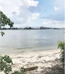  ??  ?? At Crescent Park, part of New Orleans’ riverfront developmen­t, trail users pass a sliver of beach on the Mississipp­i River.