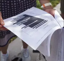  ?? AP photo ?? Journalist­s gather outside the Paul S. Rogers Federal Building and U.S. Courthouse in downtown West Palm Beach, Fla., to read a heavily blackout document released by The Justice Department Friday. The 32-page affidavit, even in its heavily redacted form, offers the most detailed descriptio­n to date of the government records being stored at former President Donald Trump’s Mar-a-Lago property long after he left the White House and reveals the gravity of the government’s concerns that the documents were there illegally.