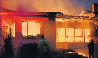  ?? Picture: LOUISE CARTER ?? FIGHTING THE FLAMES: The Ndlambe Fire Department fight the relentless fire that gutted a home in Becker Street last week