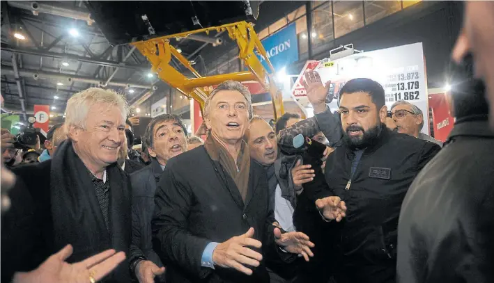  ?? GERMÁN GARCÍA ADRASTI ?? Pabellón azul. Maurico Macri rodeado de expositore­s y productore­s en su recorrida por la muestra. El Presidente se detuvo en los stands de maquinaria agrícola.