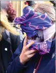  ??  ?? The 19-year-old British woman covers her face as she leaves court