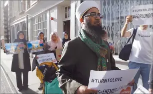  ??  ?? Mohammad Yazdani Raza, Chairman of the London Fatwa Council, hold a sign as he marches near Borough Market in London on Sunday.