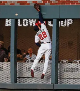  ?? KEVIN C. COX / GETTY IMAGES ?? Nick Markakis of the Braves leaps but fails to make a play Monday on an RBI double hit by Howie Kendrick of the Washington Nationals.