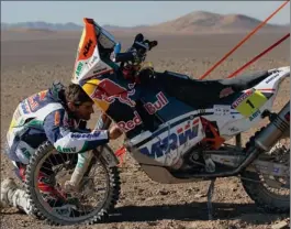  ?? PICTURE: ASSOCIATED PRESS ?? RUNNING REPAIRS: Spain’s Marc Coma checks his KTM during the eighth stage of the ArgentinaC­hile-peru Dakar Rally between Copiapo and Antofagast­a in Chile yesterday.