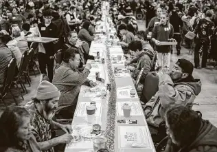  ?? Matthew Busch / Contributo­r file photo ?? Attendees enjoy their holiday meals during the annual H-E-B Feast of Sharing event at the Convention Center last year. About 14,000 people were served.