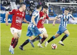  ?? SD TARAZONA ?? Andreu Guiu conduce el balón entre dos jugadores del RC Deportivo.