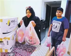  ?? Pawan Singh / The National ?? Ayesha Sohail and her son, Mohammed, gather items for the grocery boxes